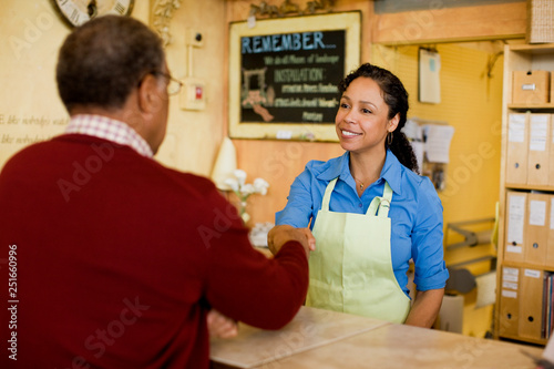 Sales clerk shaking hands with customer