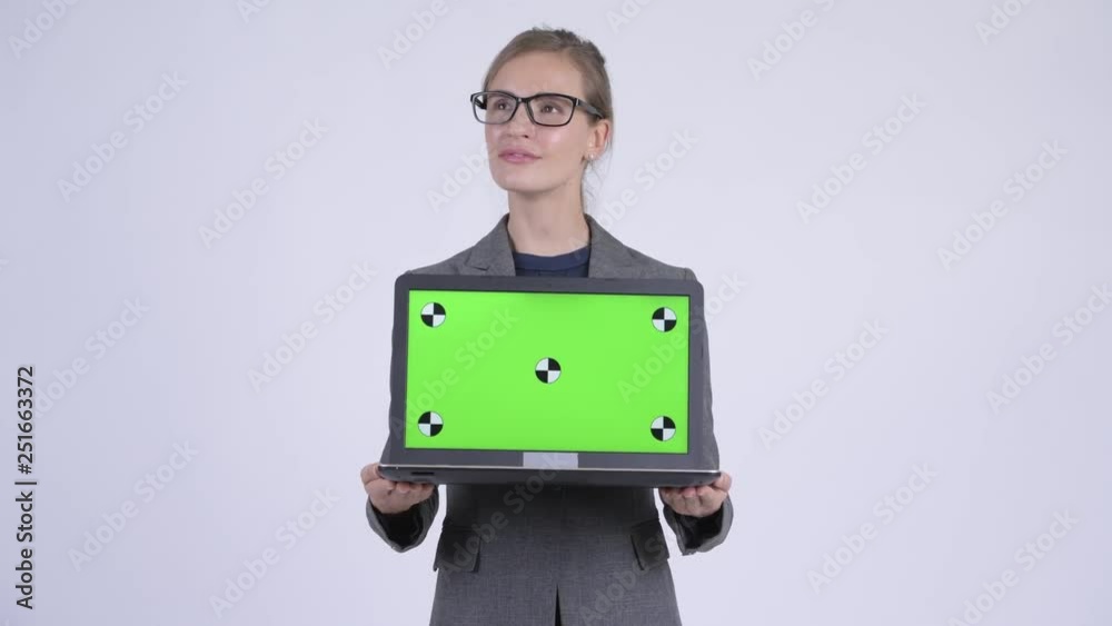 Young happy businesswoman thinking while showing laptop Young happy businesswoman thinking while showing laptop