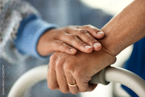Close up of nurse hand supporting and comforting patient's hand