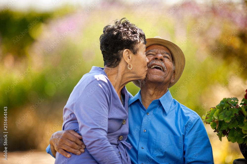 © Erickson Stock - Senior woman kissing her happy husband. © Erickson Stock - Senior woman kissing her happy husband.