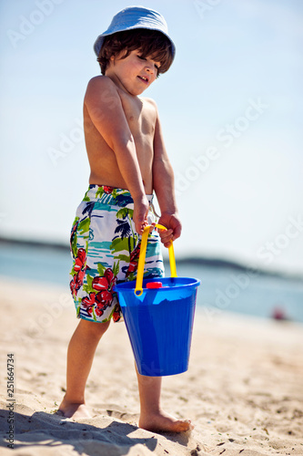 Young boy with bucket of sand. photo