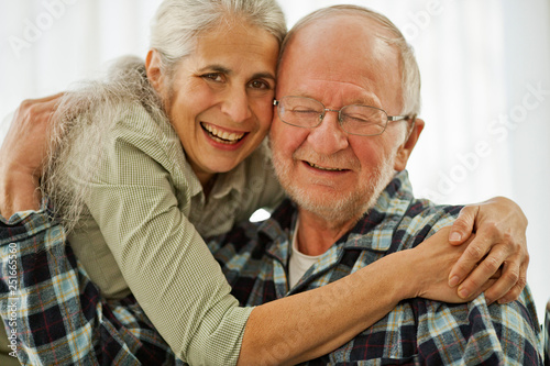 Portrait of a senior woman with her arms around her husband.