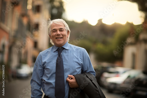 Portrait of a smiling mature businessman walking home from work. photo