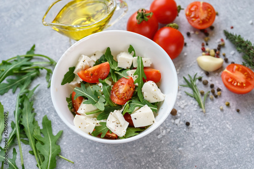 Italian cuisine. Vegetarian food. Salad with mozzarella, arugula and cherry tomatoes.