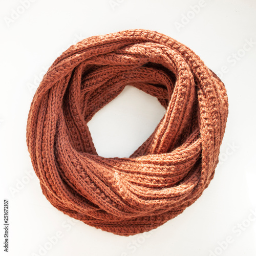 Brown-red knitted scarf on white background