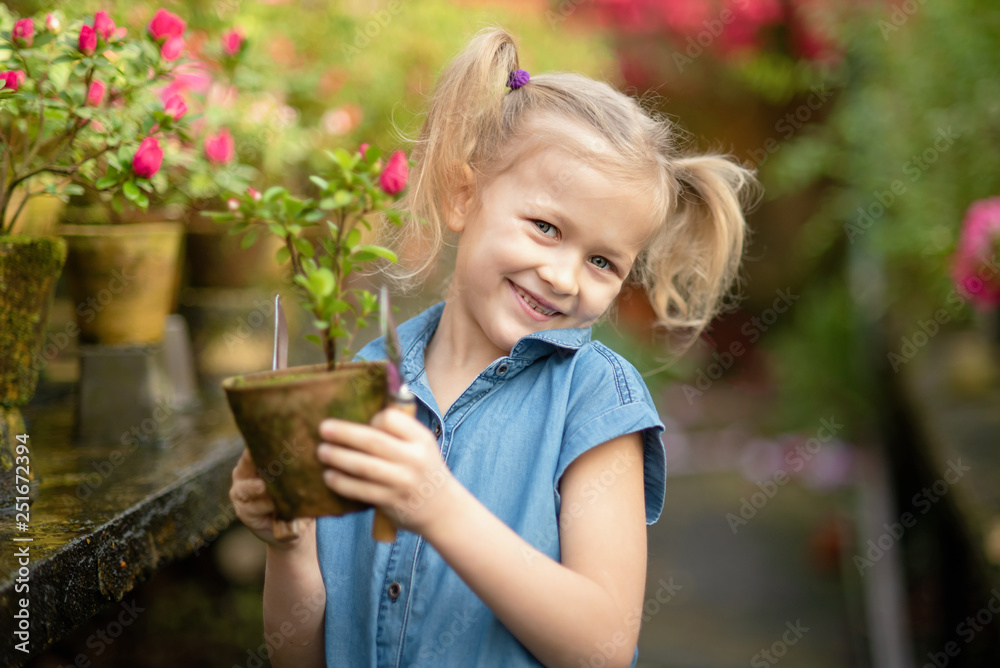 Fototapeta premium Toddler with flower basket. girl holding pink flowers