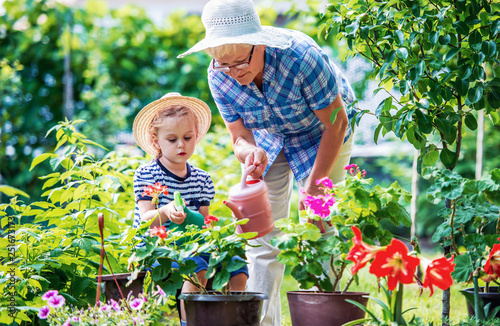 Gardening with kids. Senior woman and her grandchild working in the garden with a plants. Hobbies and leisure, lifestyle, family life