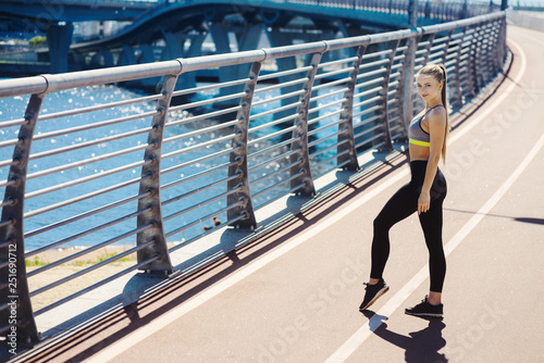 Young beautiful woman in sportswear. Going to do sports training, gymnastics in the gym. Outdoors summer fashion. Healthy sports lifestyle concept