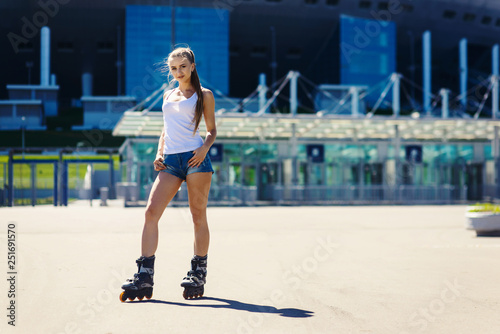 Portrait of a beautiful sexy young blonde girl on roller skates, in denim shorts and a T-shirt. Smiling and lookind at camera. Hot summer day. Outdoor city sports. Healthy lifestyle concept © ANR Production