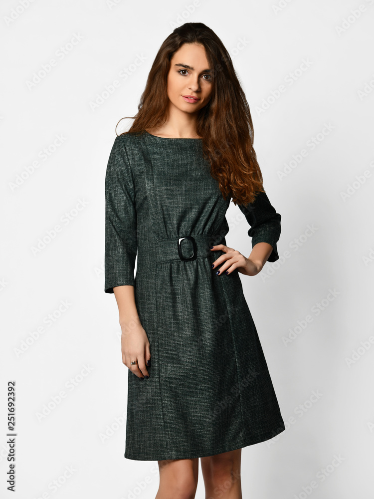 Young beautiful woman posing in new design casual green winter dress on grey Young beautiful woman posing in new design casual green winter dress on grey