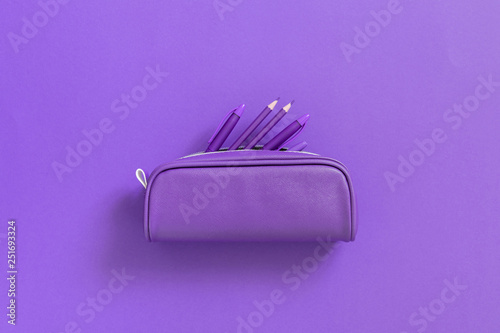 Fototapeta Purple school supplies in pencil case on background of purple paper