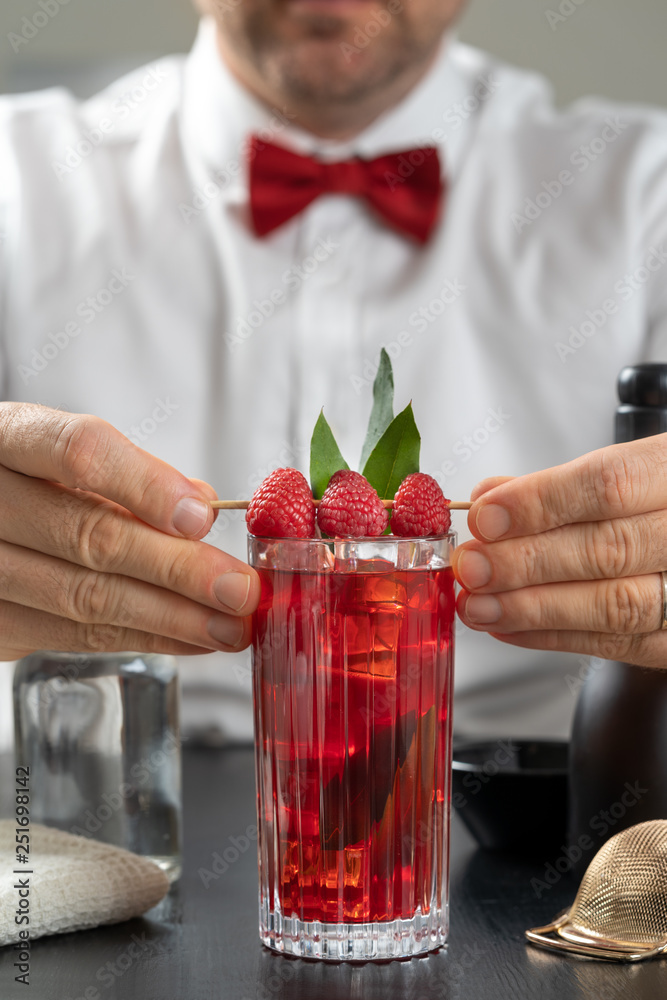classy fancy bartender mixologist makes prepares alcohol drink cocktail bowtie raspberry