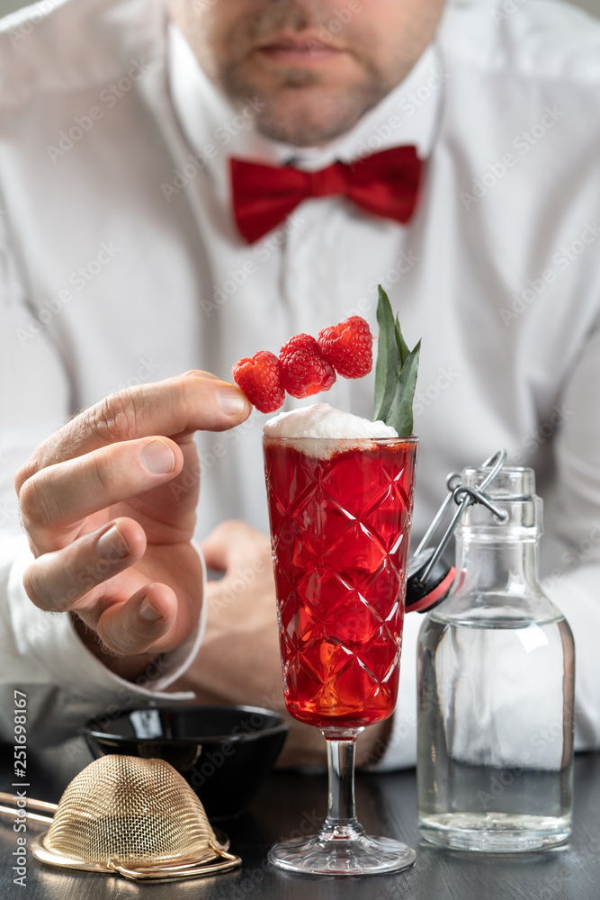 classy fancy bartender mixologist makes prepares alcohol drink cocktail bowtie raspberry