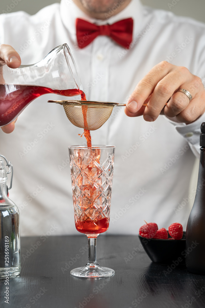 classy fancy bartender mixologist makes prepares alcohol drink cocktail bowtie raspberry
