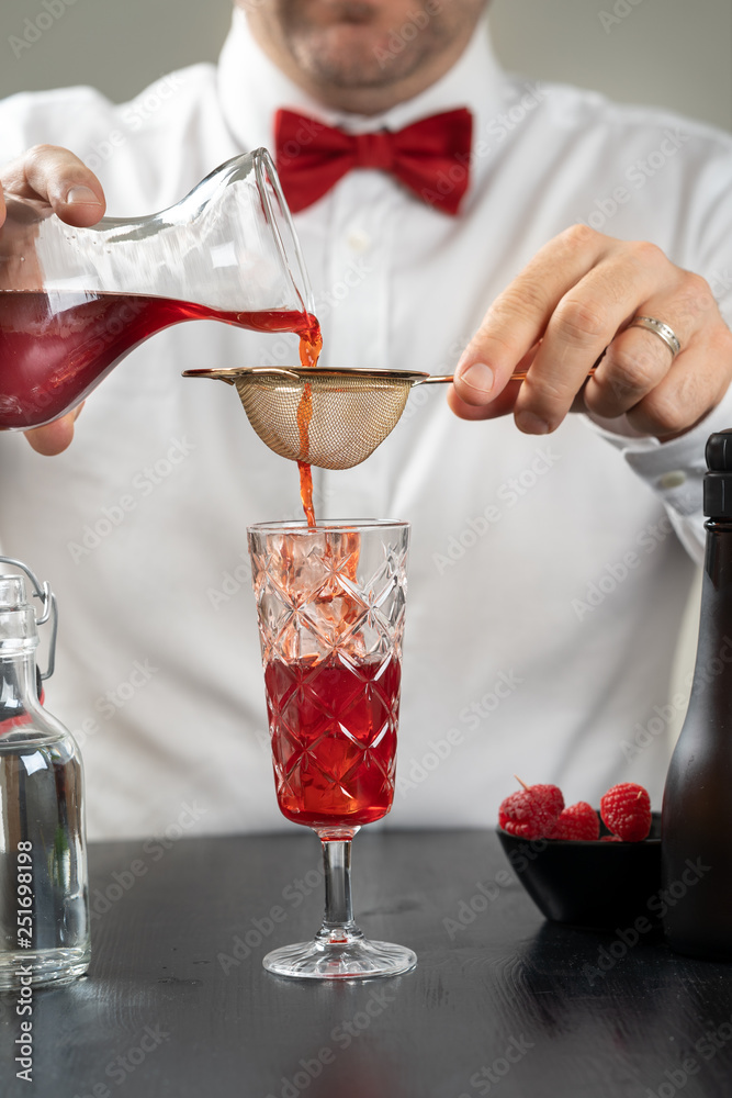 classy fancy bartender mixologist makes prepares alcohol drink cocktail bowtie raspberry