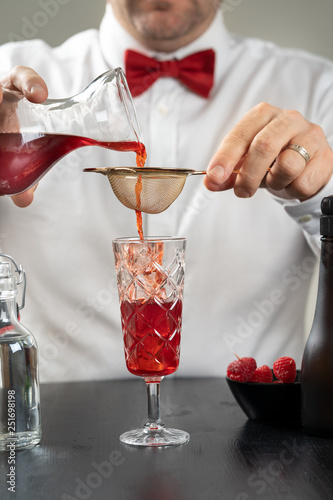 classy fancy bartender mixologist makes prepares alcohol drink cocktail bowtie raspberry 
