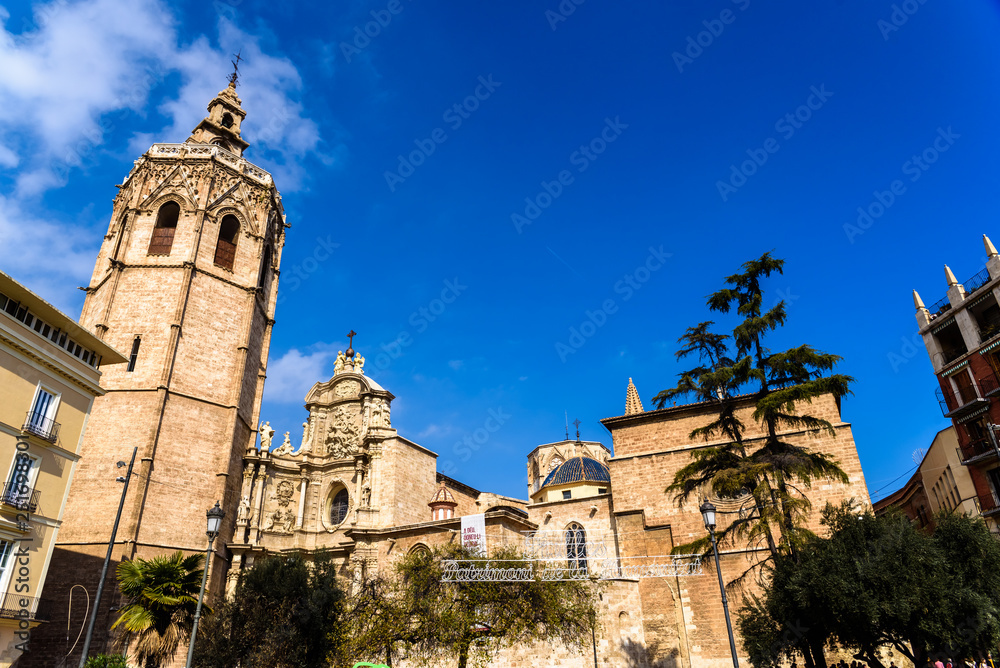 Valencia, Spain - February 24, 2019: Plaza de la Reina a sunny spring day during Fallas, with the Cathedral of Valencia and its tower Miguelete.