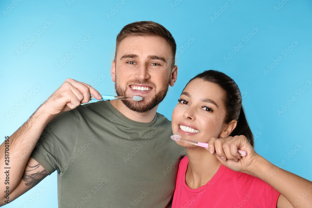 Obraz premium Young couple with toothbrushes on color background. Teeth care