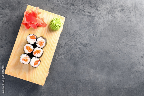 Tasty sushi rolls served on grey table, top view with space for text. Food delivery