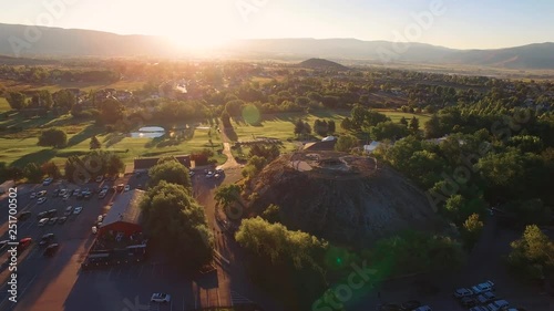 Drone Slow Pan Left To Right Crater With Course In Background. The clip shows a circumnavigational shot against sunset around the Homestead resort. Parking lot, trees, cars, rooftops, and plants. photo