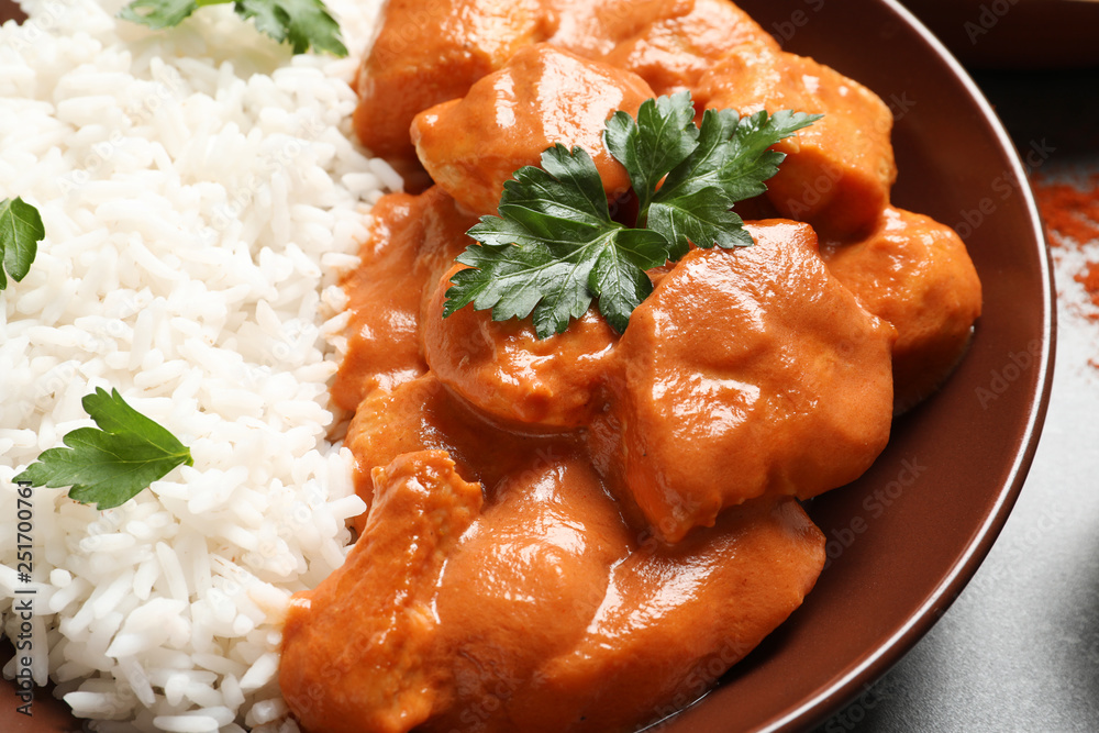 Plate of delicious butter chicken with rice on table, closeup Plate of delicious butter chicken with rice on table, closeup