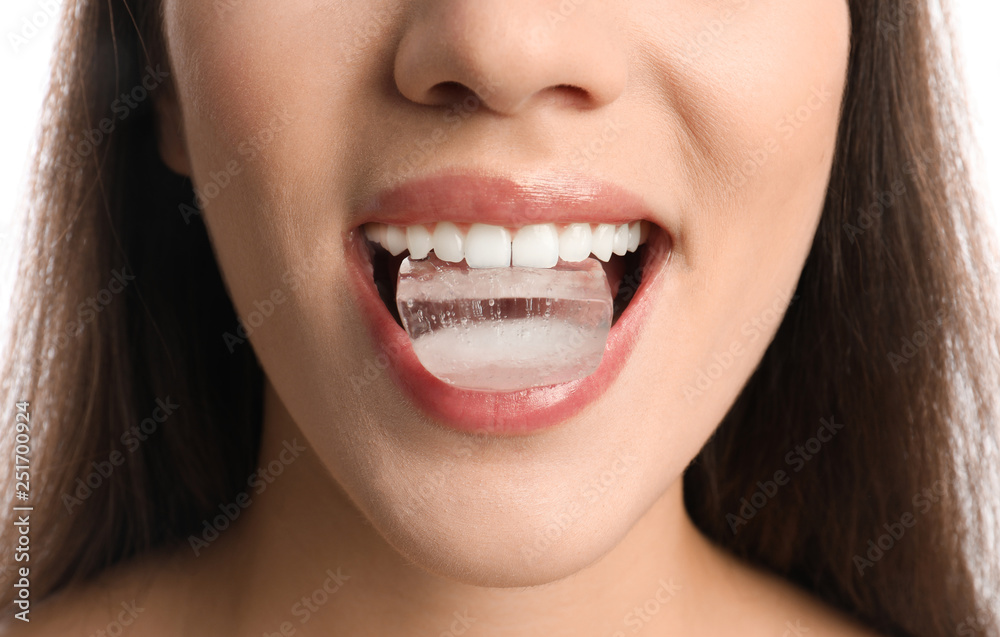 Young woman holding ice cube in mouth, closeup Young woman holding ice cube in mouth, closeup