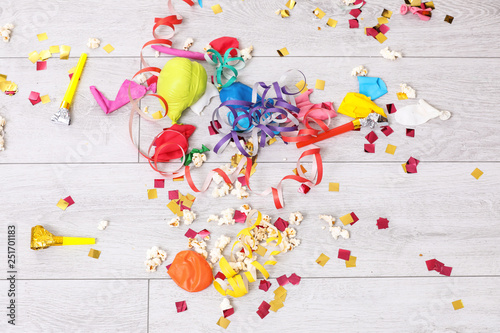 Messy floor with popcorn, streamers, confetti and used balloons after party, top view