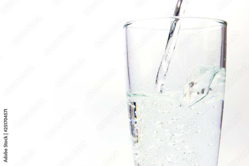 pouring water on a glass on white background pouring water on a glass on white background