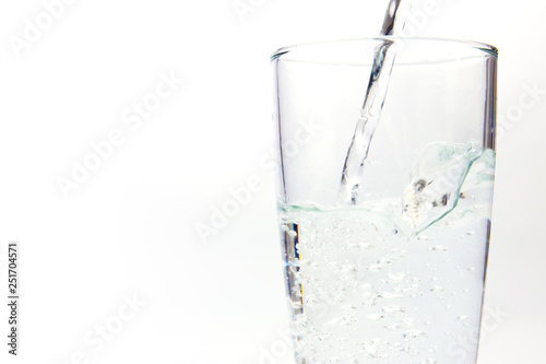 pouring water on a glass on white background 