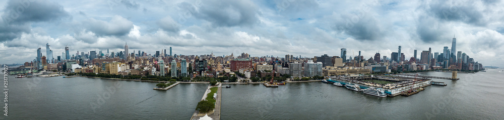 Aerial view of Manhattan Midtown and Downtown skyline from above Hudson River on a cloudy day