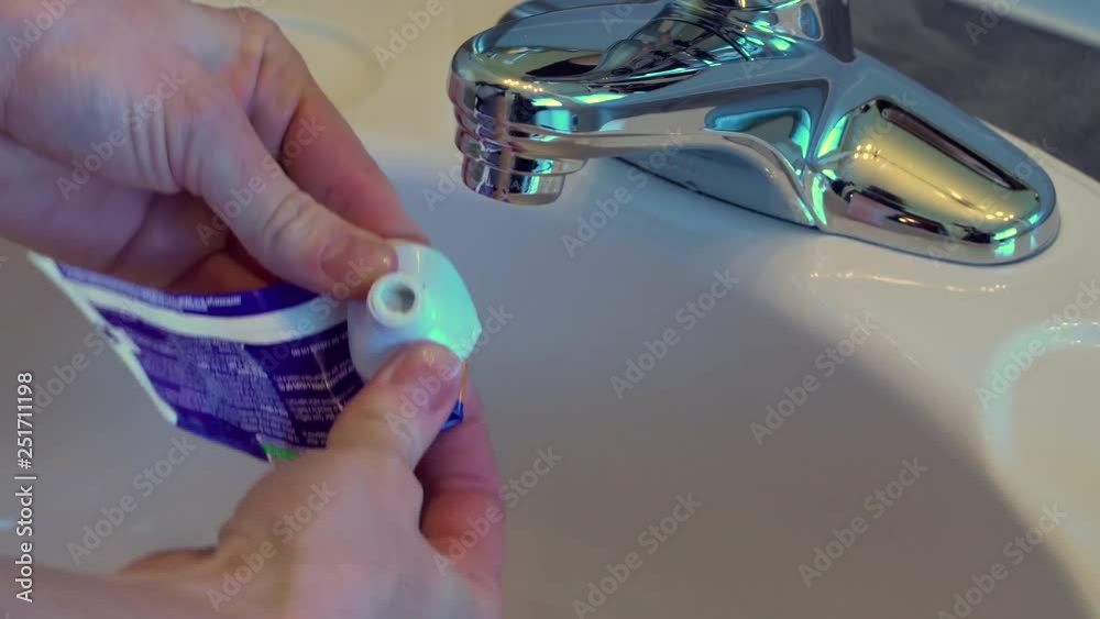 Female hands squeezing an empty toothpaste tube.