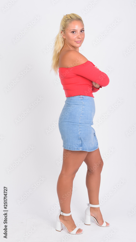 Full body shot profile view of young beautiful blonde woman looking at camera Full body shot profile view of young beautiful blonde woman looking at camera
