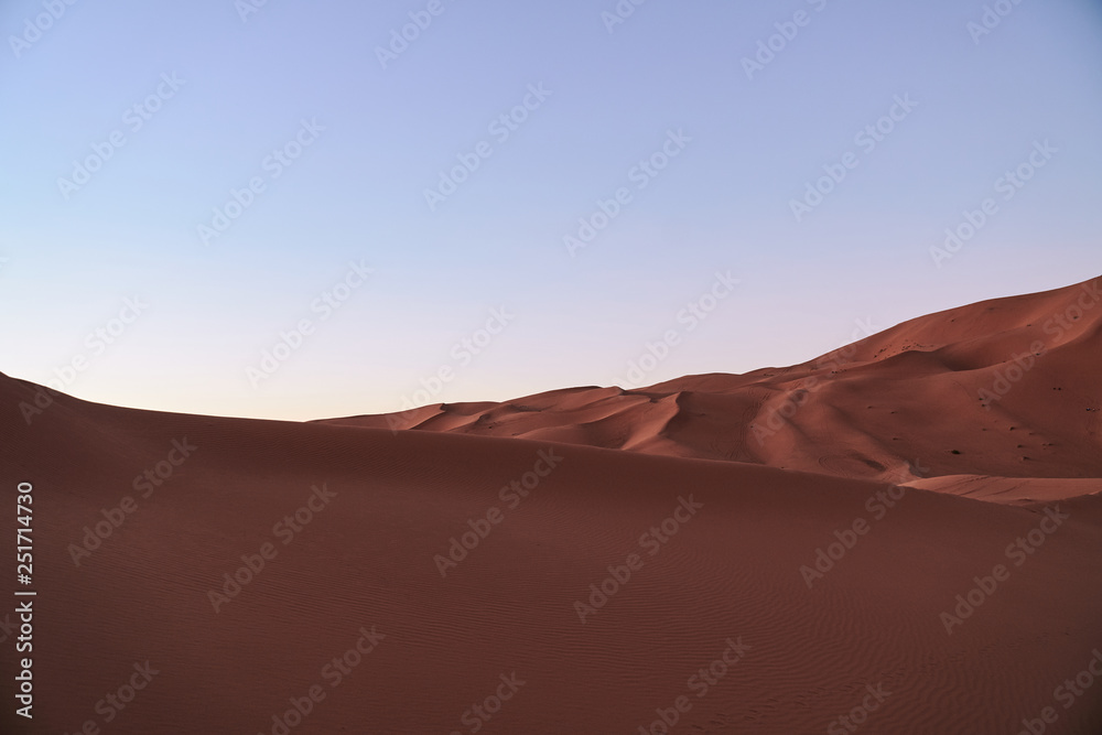 Wave shaped dunes in Sahara desert after sunset in Morocco Africa