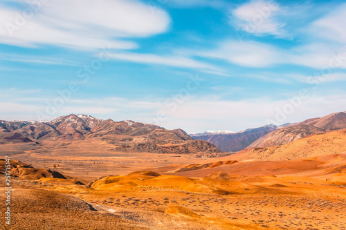Yellow and red rocks under blue sky. Desert landscape with mountains.