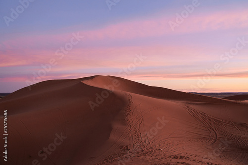 Beautiful colorful pink and yellow sunset on a dune in Sahara desert Morocco Africa