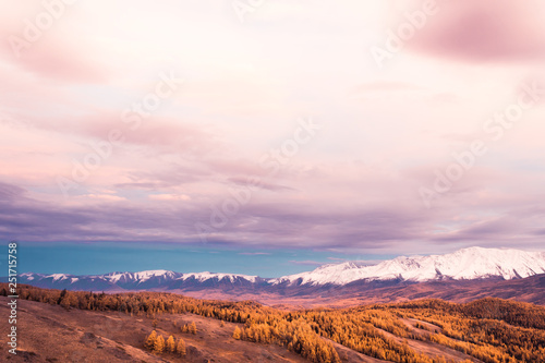 Pink and purple clouds over mountain range. Sunset or dawn in mountains in autumn. Hiking trip to valley of mountains. © Koirill