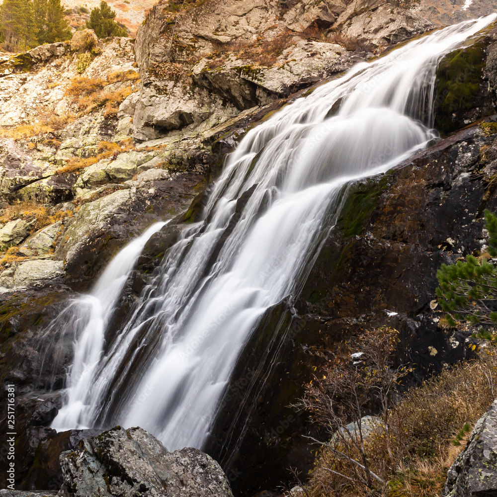 Waterfall in rocks. Fast mountain river