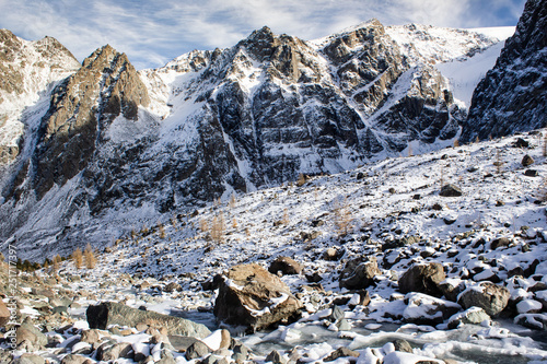 Top of mountain under snow and blue sky. Climbing the rocks, alipinism. Winter panorama of Altai mountain gorge.