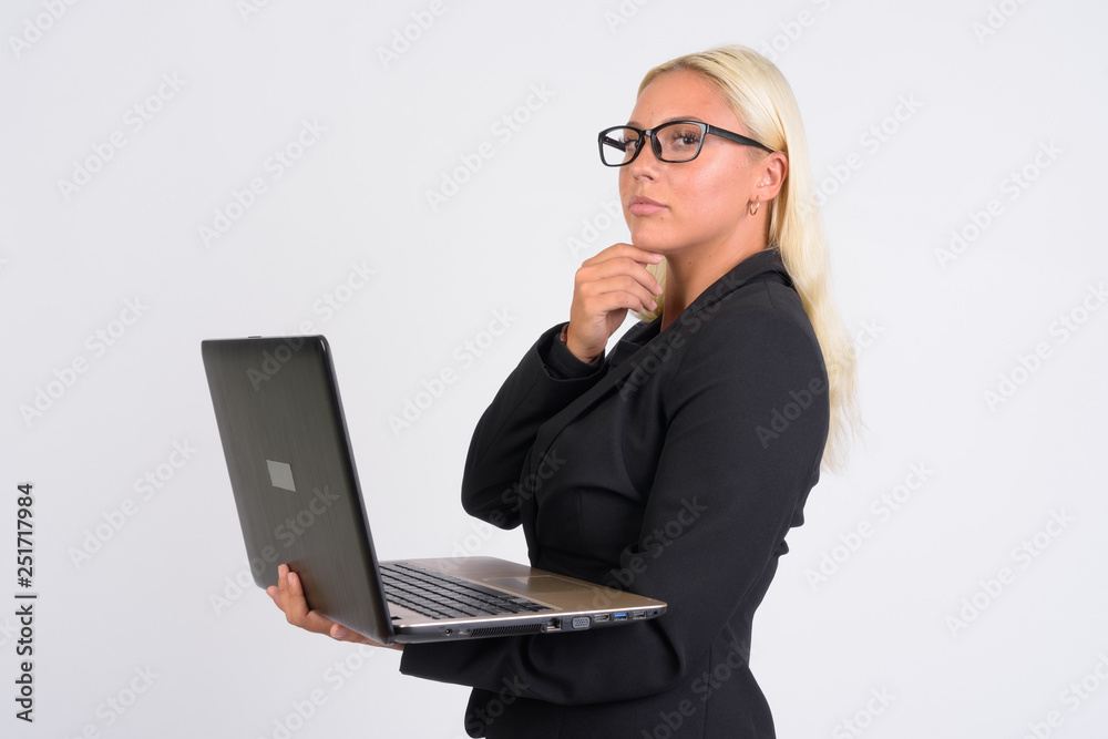 Portrait of young blonde businesswoman thinking while using laptop Portrait of young blonde businesswoman thinking while using laptop