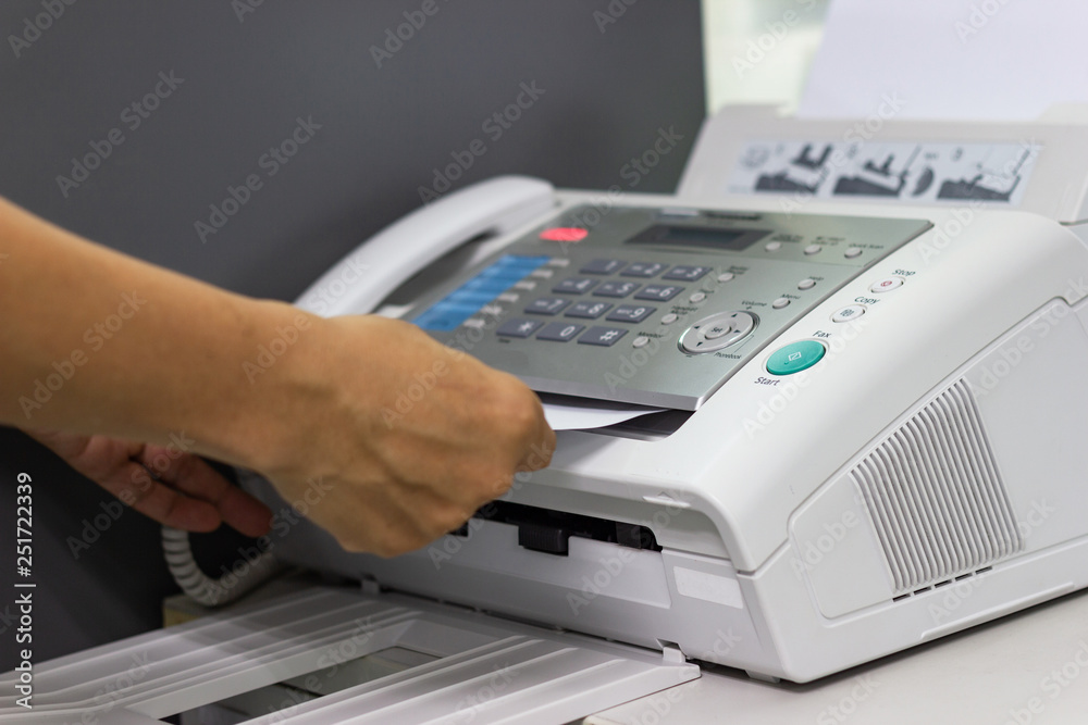 hand  of man are using a fax machine in the office Business concept  - obrazy, fototapety, plakaty 