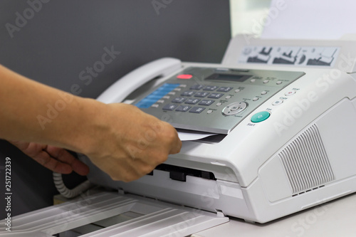 hand  of man are using a fax machine in the office Business concept  photo