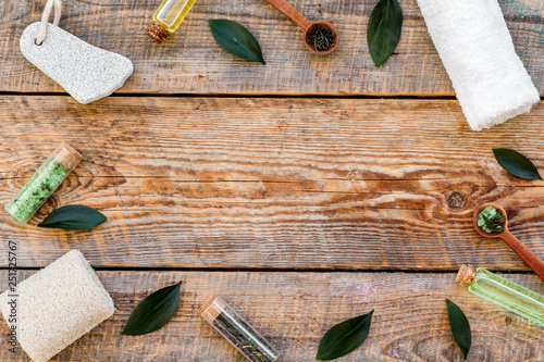 Tea tree spa composition. Fresh tea tree leaves, natural cosmetics, towel on rustic wooden background top view copy space frame