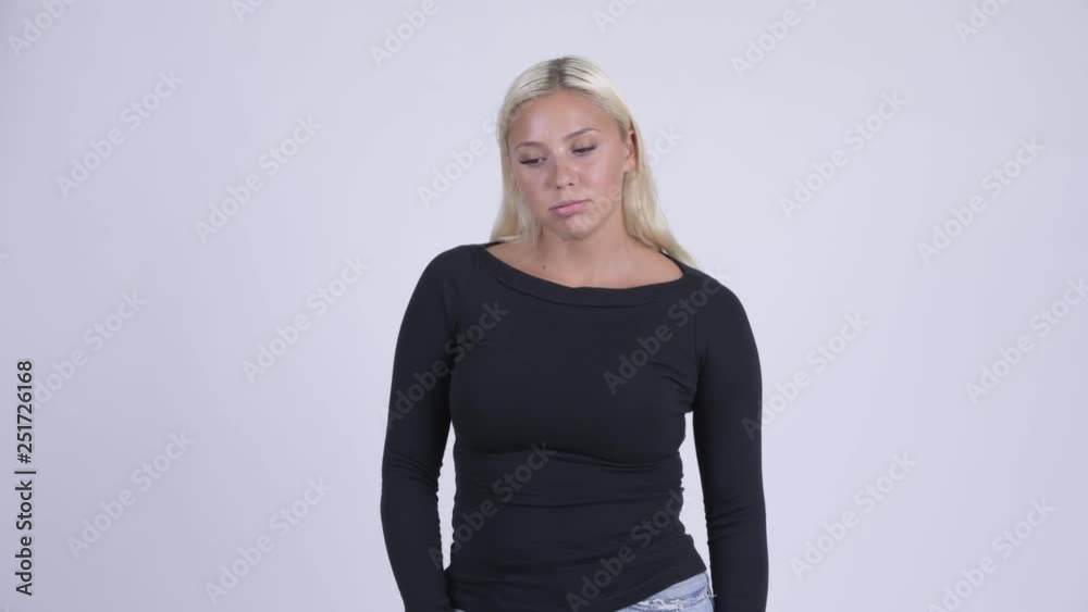 Young serious blonde woman thinking and looking down Young serious blonde woman thinking and looking down
