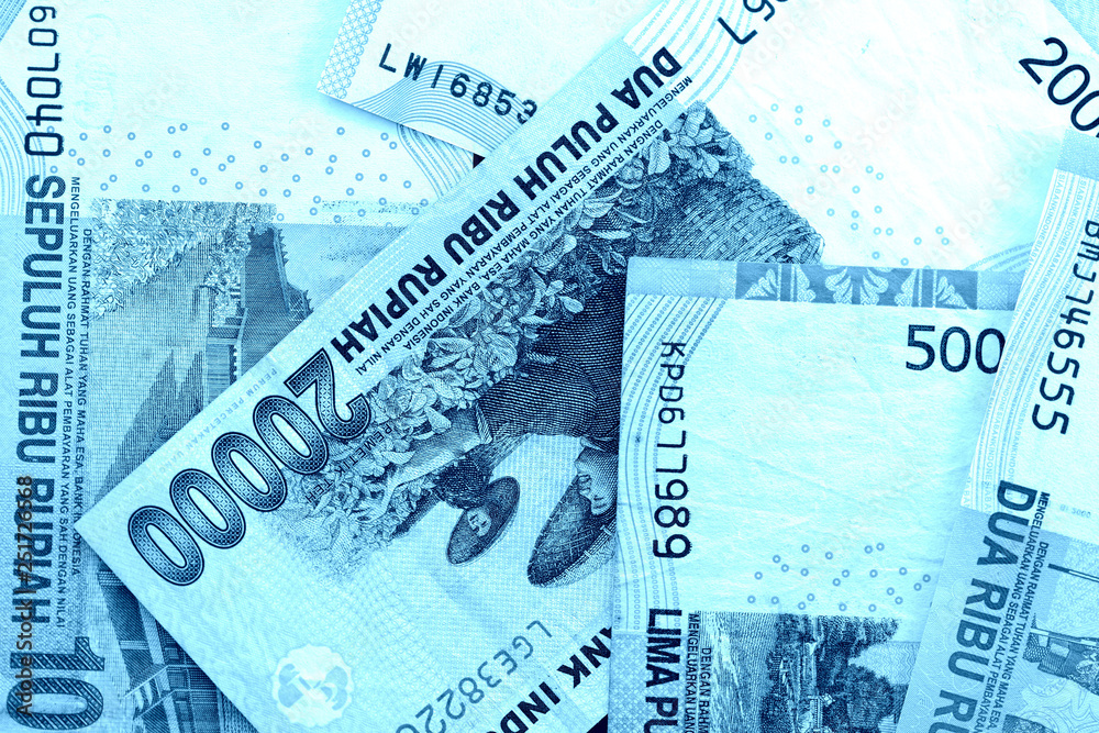 Fototapeta premium Several Indonesian rupiah banknotes close up. Blue color toned
