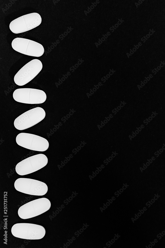 Pills or tablets on black background