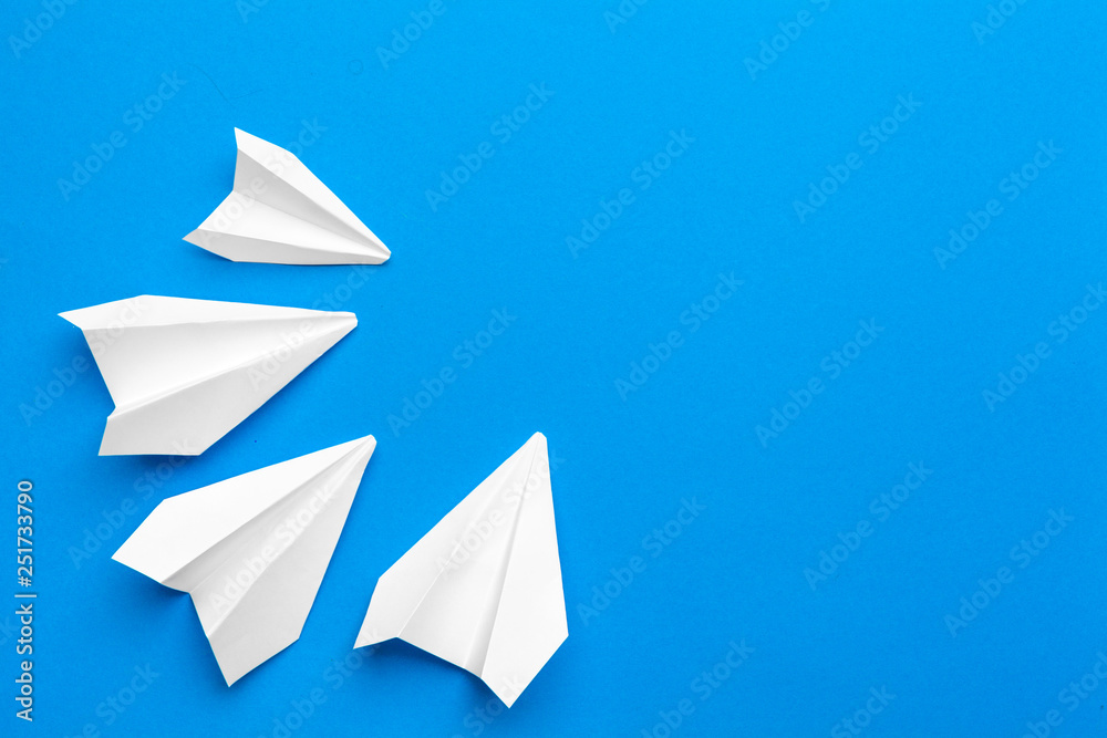 white paper airplane on a navy paper background white paper airplane on a navy paper background