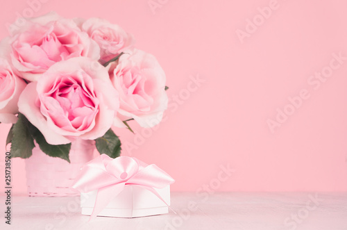 Wedding decor and gift for home in romantic style -pastel pink roses in basket and gift box with silk ribbon on white wood table, copy space.