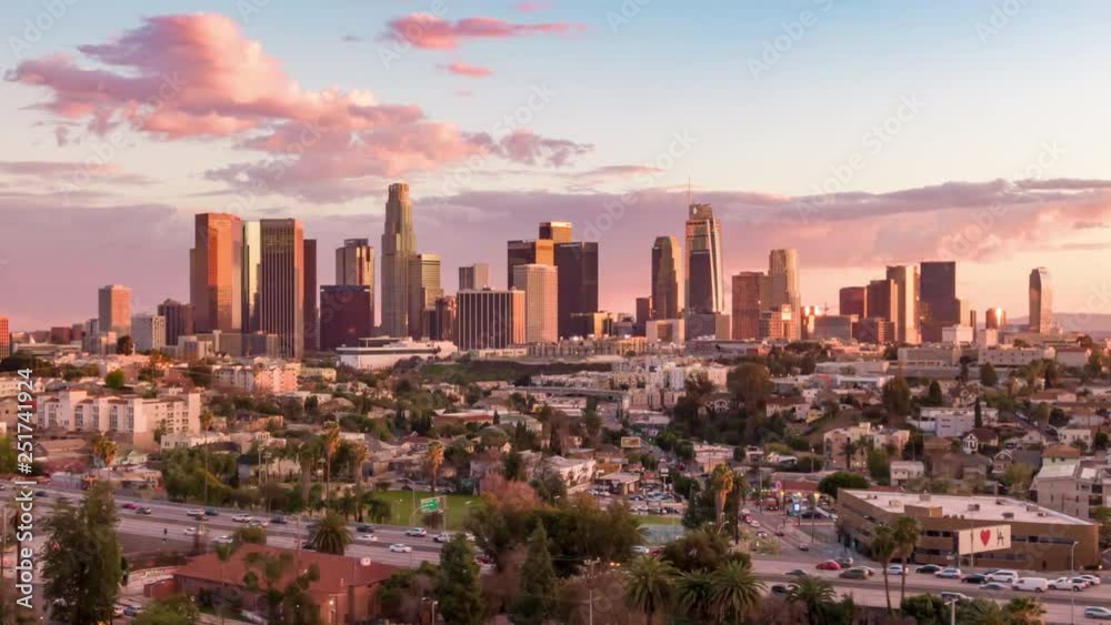 Aerial time lapse in motion or hyperlapse over Echo Park of downtown Los Angeles, California skyline and skyscrapers from above on a sunny day during golden hour before sunset.