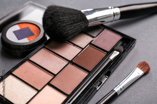 Makeup brushes and eyeshadows on table, closeup