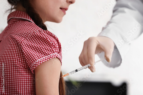 Doctor giving diabetic girl an insulin injection